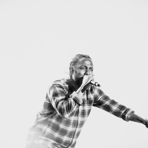 Black and white photograph of Kendrick Lamar performing onstage
