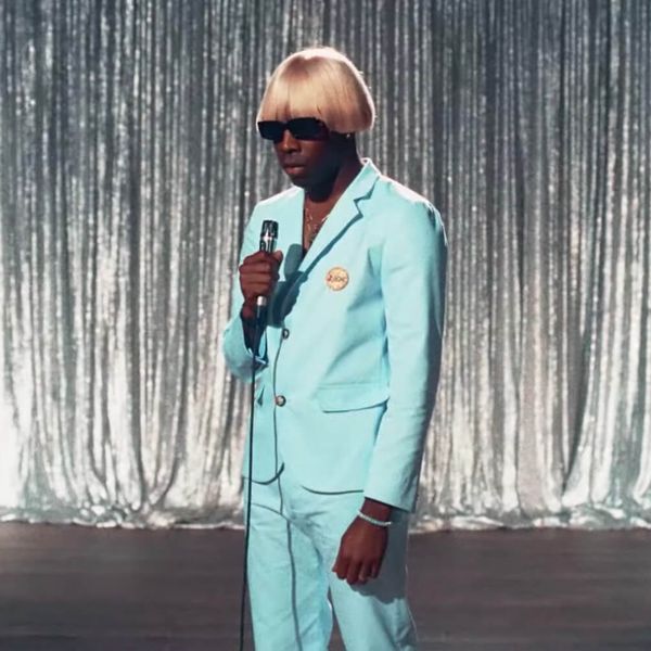 Tyler, the Creator wearing a dashing baby blue suit and monstrous blonde wig