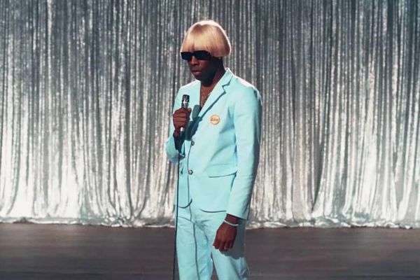 Tyler, the Creator wearing a dashing baby blue suit and monstrous blonde wig
